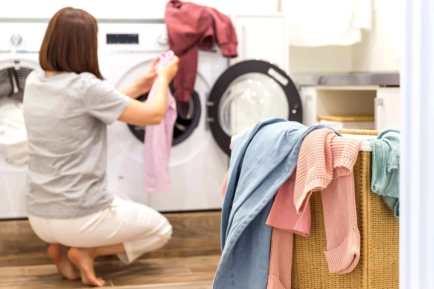 Woman Loading Dirty Clothes In Washing Machine 