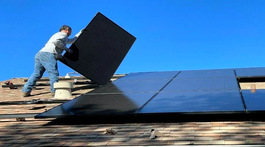 man installing solar attic fan